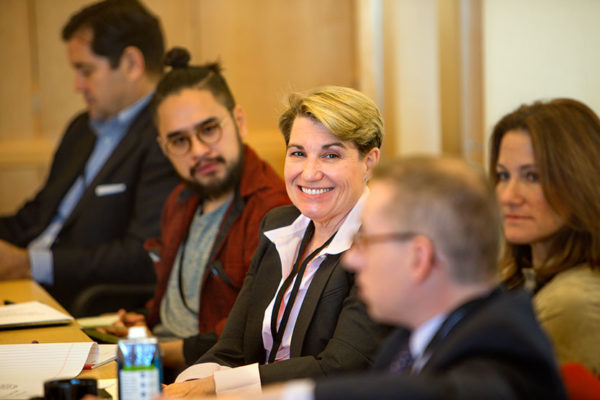 Woman smiliing during meeting with others looking on