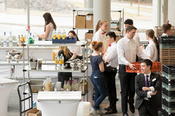 Students work in a busy industrial kitchen.