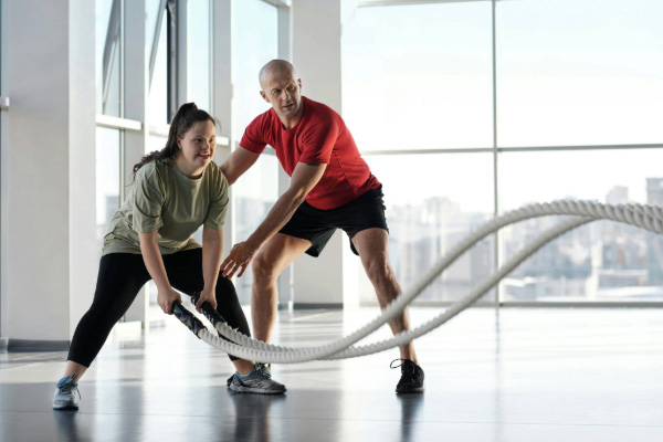 Woman holding ropes beside a trainer