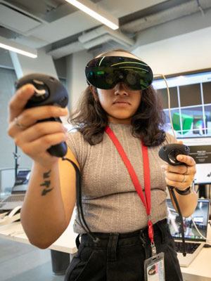 Business student using a VR headset and controllers in a Cornell Tech lab